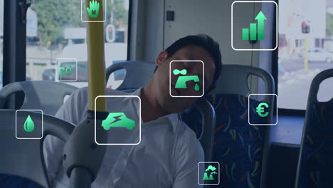 Animation-of-energy-and-ecology-icons-over-asian-man-asleep-on-bus