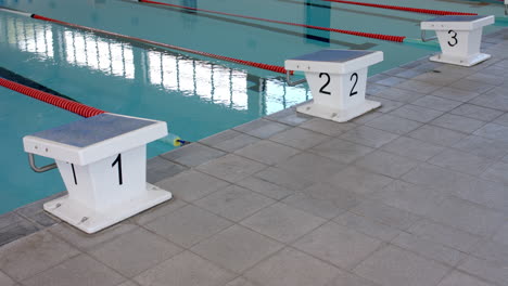 Starting-blocks-at-the-edge-of-a-swimming-pool,-ready-for-a-race