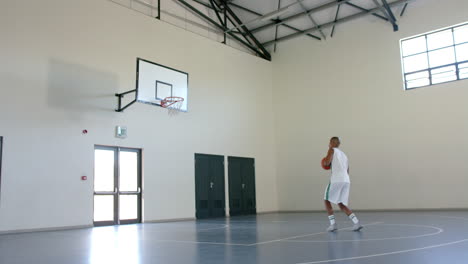 African-American-man-practices-basketball-in-a-gym,-with-copy-space