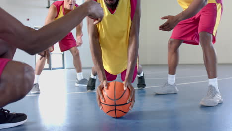 Young-African-American-man-doing-push-ups-on-a-basketball-in-an-indoor-court