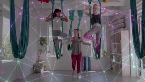 Animation-of-network-over-diverse-female-instructor-and-teenager-girls-practicing-aerial-yoga