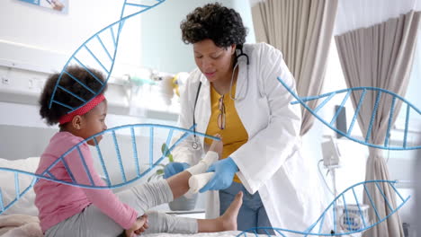 Animation-of-dna-strands-over-african-american-female-doctor-bandaging-leg-of-girl-patient