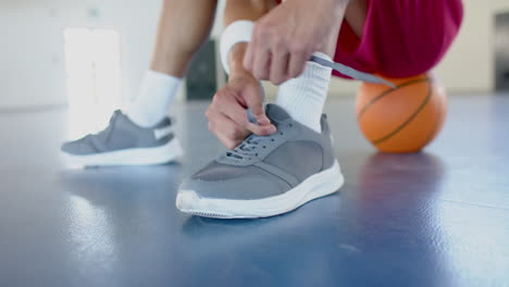 Athlete-ties-shoelaces-on-the-basketball-court