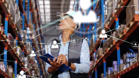 Animation-of-network-of-connections-with-icons-over-caucasian-man-working-in-warehouse