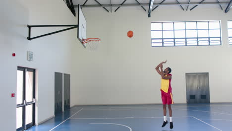 A-basketball-player-shoots-for-the-hoop-in-an-indoor-court
