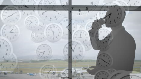 Animation-Fallender-Uhren-Mit-Schnellen-Zeigern-über-Einem-Kaukasischen-Geschäftsmann-Am-Flughafen,-Der-Sein-Smartphone-Benutzt