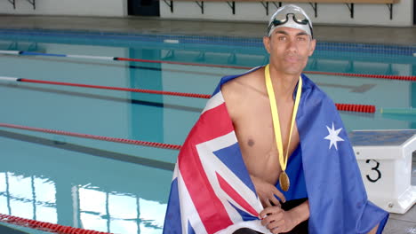 Stolzer-Schwimmer-Zeigt-Seine-Medaille-Am-Pool-Mit-Einer-Australischen-Flagge,-Mit-Kopierraum