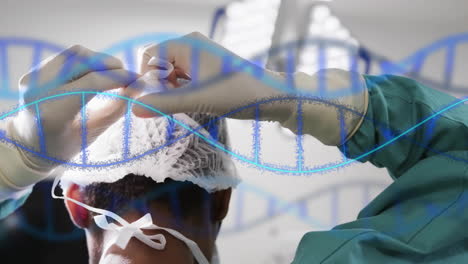 Animation-of-dna-strands-over-african-american-male-surgeon-tying-surgical-mask-in-theatre