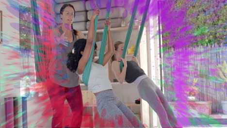 Animation-of-colourful-trails-over-diverse-female-instructor-and-teenage-girls-doing-aerial-yoga