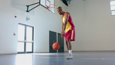 African-American-man-practices-basketball-in-a-gym