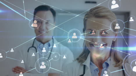 Animation-of-network-of-connections-with-icons-over-caucasian-doctors-smiling