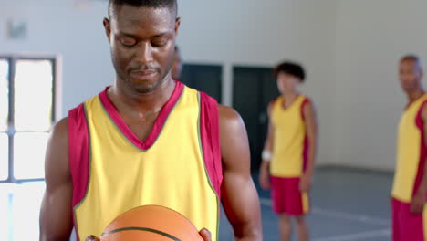 Fokussierter-Afroamerikanischer-Mann,-Der-Einen-Basketball-In-Einem-Fitnessstudio-Hält