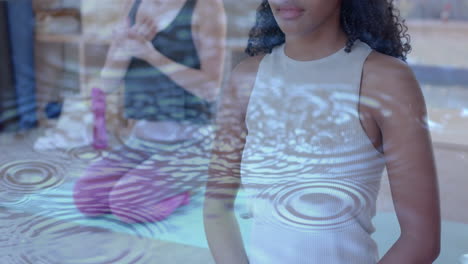 Animation-of-ripples-in-water-over-happy-diverse-teenage-girls-practicing-yoga-meditation