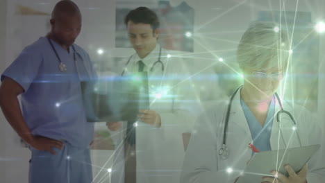 Animation-of-glowing-communication-network-over-diverse-male-and-female-doctors-at-work-in-hospital