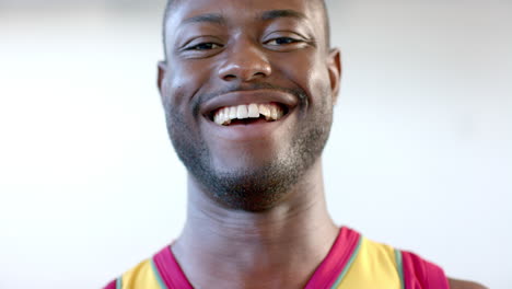Un-Joven-Jugador-De-Baloncesto-Afroamericano-Sonríe-Ampliamente,-Mostrando-Una-Expresión-Alegre