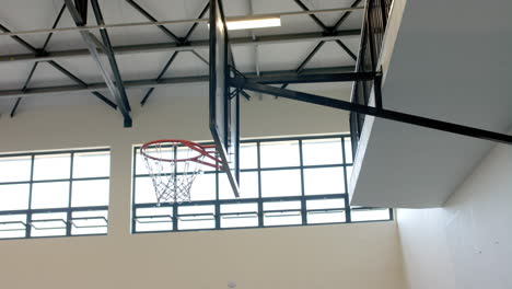 Indoor-basketball-hoop-in-a-gymnasium,-with-copy-space