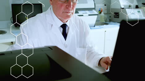 Animation-of-hexagons-over-caucasian-male-scientist-using-computer-in-lab