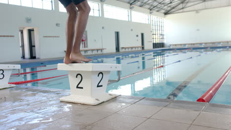 Athlet-Balanciert-Auf-Einem-Startblock-In-Einem-Pool,-Mit-Kopierraum
