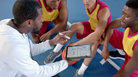Afroamerikanischer-Trainer-Bespricht-Strategie-Mit-Spielern-Auf-Dem-Platz