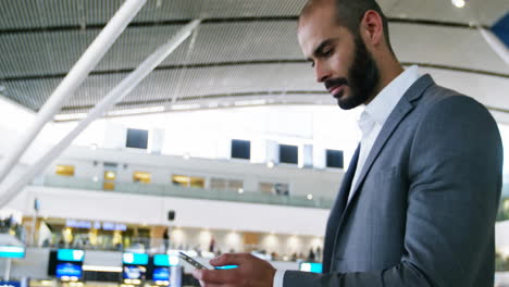 Animation-of-social-media-notifications-over-biracial-businessman-using-smartphone-at-airport