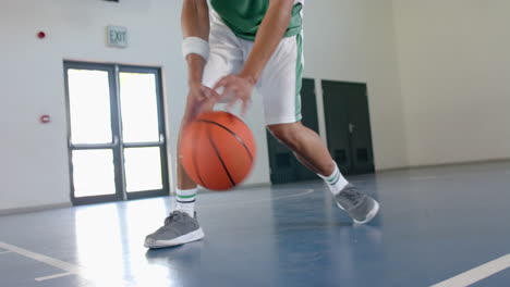Young-biracial-man-plays-basketball-indoors