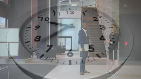 Animation-of-clock-with-fast-moving-hands-over-diverse-male-and-female-colleague-talking-in-foyer