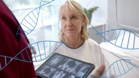 Animation-of-dna-strands-over-diverse-male-doctor-with-tablet-and-senior-female-patient