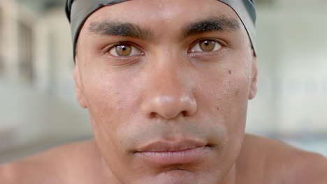 Close-up-of-a-young-biracial-male-athlete-swimmer-wearing-a-swim-cap