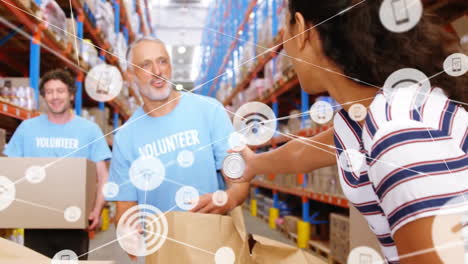 Animation-of-network-of-connections-with-icons-over-diverse-volunteers-working-in-warehouse