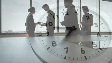 Animation-of-clock-with-fast-moving-hands-over-diverse-business-colleagues-talking