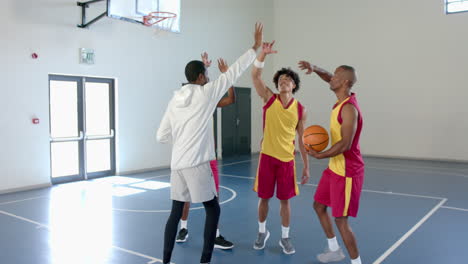 Young-African-American-man-celebrates-with-teammates-in-a-gym