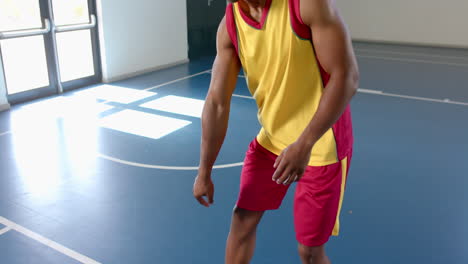 Hombre-Afroamericano-Sostiene-Una-Pelota-De-Baloncesto-En-El-Gimnasio