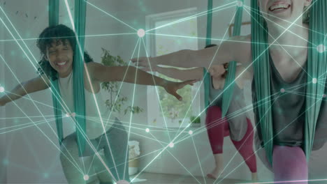 Animation-of-glowing-network-over-diverse-female-instructor-and-teenage-girls-practicing-aerial-yoga