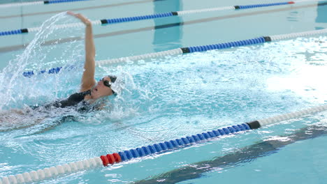 Caucasian-female-swimmer-athlete-swimming-in-a-pool