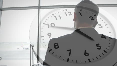 Animation-Einer-Uhr-Mit-Schnellen-Zeigern-über-Einem-Kaukasischen-Geschäftsmann-Am-Flughafen,-Der-Auf-Dem-Smartphone-Spricht