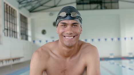 Young-biracial-male-athlete-swimmer-smiles-at-the-camera-in-a-swimming-pool