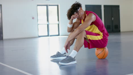Junger-Afroamerikaner-Sitzt-Niedergeschlagen-Auf-Einem-Basketballplatz