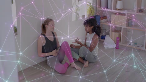Animation-of-glowing-network-over-happy-diverse-teenage-girls-talking-at-yoga-class