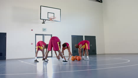Diverse-basketball-players-practice-in-an-indoor-court
