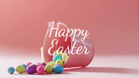 Animation-of-happy-easter-text-over-colourful-easter-eggs-and-pink-bucket-on-pink-background