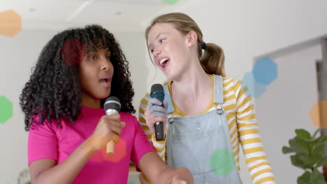Animation-of-coloured-lights-over-happy-diverse-teenage-girls-with-microphones-singing-at-home