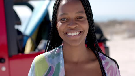 A-young-African-American-woman-smiles-brightly-outdoors-on-a-road-trip
