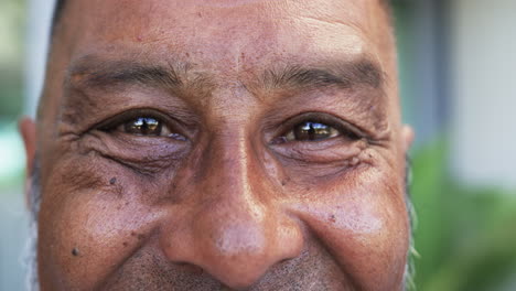 Close-up-of-a-biracial-man-with-a-warm-smile,-showcasing-his-brown-eyes-and-subtle-wrinkles