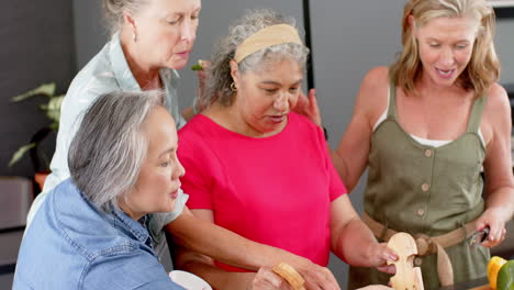 Senior-diverse-group-of-women-engaged-in-a-cooking-class-at-home