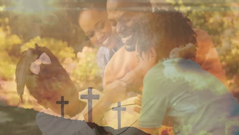Animation-of-clouds-and-crosses-over-happy-african-american-family