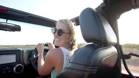 Young-Caucasian-woman-enjoys-a-sunny-drive-in-a-convertible-on-a-road-trip