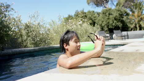 Teenage-Asian-boy-enjoys-a-sunny-day-in-an-outdoor-pool