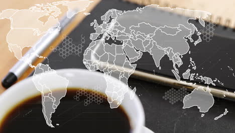 Animation-of-world-map-over-laptop-and-cup-of-coffee-on-desk