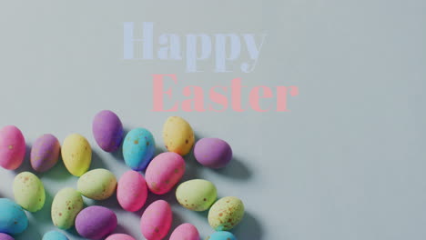 Animation-of-happy-easter-text-over-colourful-easter-eggs-on-grey-background