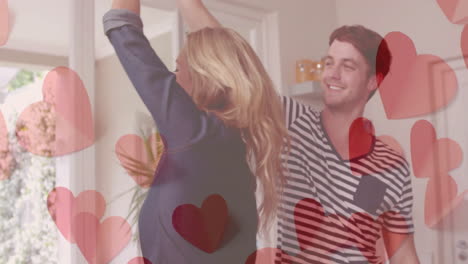 Animation-of-hearts-over-happy-diverse-couple-dancing-at-home